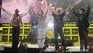 Van Halen standing onstage and waving to the audience