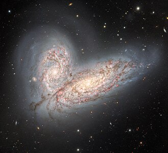 A pair of interacting spiral galaxies — NGC 4568 (bottom) and NGC 4567 (top) — as they begin to clash and merge.