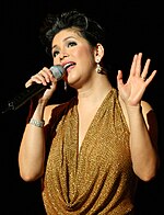 An image of Regine Velasquez holding a microphone.