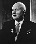 An elderly man in a suit, with three medals pinned on it