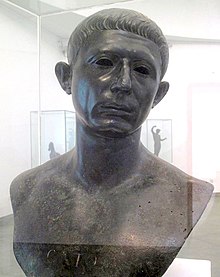 A bronze bust of the head and shoulders of a middle-aged man, with the word "CATO" inscribed across the chest