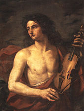 A young man with long flowing hair, bare chested, holds a stringed instrument in his left hand, while looking way to the left with a soulful expression.