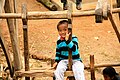 A Gurung child playing on a traditional Nepalese wooden rotatory swing