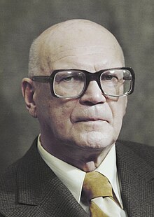 Portrait of Urho Kekkonen, a middle-aged, bald, white man wearing square glasses and a morning suit.