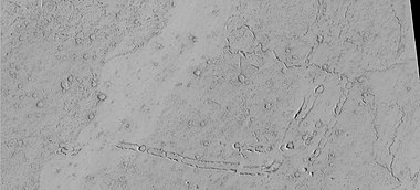 Rootless Cones, as seen by HiRISE under HiWish program. These group of rings or cones are believed to be caused by lava flowing over water ice or ground containing water ice. The ice quickly changes to steam which blows out a ring or cone. Here the kink in the chain may have been caused by the lava changing direction. Some of the forms do not have the shape of rings or cones because maybe the lava moved too quickly; thereby not allowing a complete cone shape to form. The location is the Elysium quadrangle.