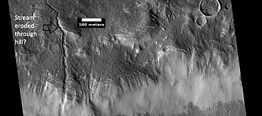 Channels, as seen by HiRISE under HiWish program. Stream appears to have eroded through a hill.