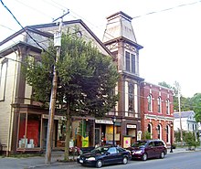 A tall building with peaked roof and a smaller brick one next to it