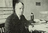 A man sits at a desk.