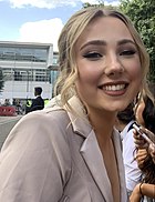 A woman wearing a beige blazer smiling