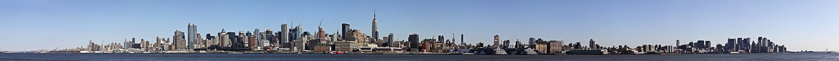 daytime skyline of a city, with a large body of water in front