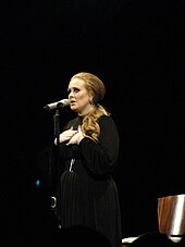 colour photograph of Adele singing live in 2011.