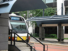 A southbound train emerging from a station featuring split side platforms.