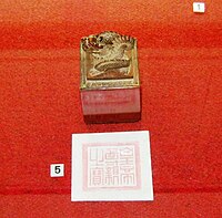 Seal, decorated with a dragon, and its imprint against a red background