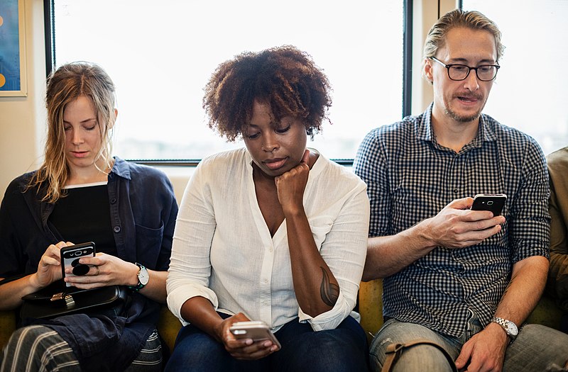 File:People concentrating on phones.jpg