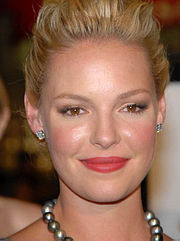 A smiling blonde woman wearing silver jewelry.