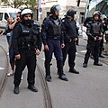 Heavily armed policemen guard the demonstration.