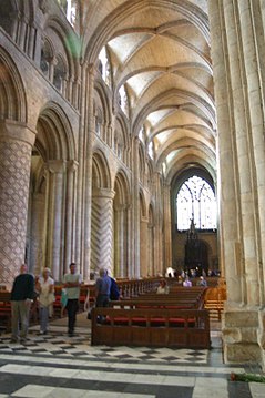 Durham Cathedral, England, has decorated masonry columns alternating with piers of clustered shafts supporting the earliest pointed high ribs.