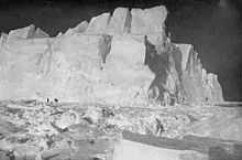 High cliffs of an iceberg set in broken pack ice