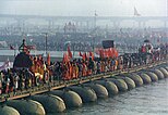 A procession of Akharas marching over a makeshift bridge over the Ganges river, Kumbh Mela at Prayag.