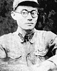 A black-and-white image of a man in a uniform and glasses