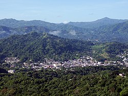 Large green mountain dotted with homes