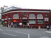 Terracotta railway station building at the bottom of a hill