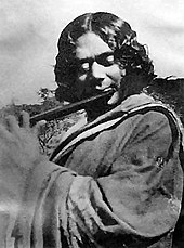 Black and white photograph of a man playing a flute