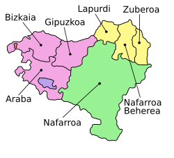 The seven provinces of the Basque Country, as claimed by certain Basque sectors, span France (light yellow) and Spain (rest of the map). The enclaves of Valle de Villaverde and Treviño are pictured in red and blue, respectively. Names on this map are in Basque.