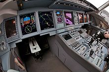 View of cockpit of modern jet airliner, showing a large array of displays and instruments.