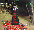 Georgian woman standing on a carpet outside near a tree