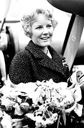 The singer Petula Clark holding a large bunch of flowers