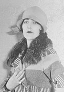 Actress Aileen Pringle wearing a cloche hat and boldly patterned coat, 1926.