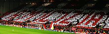 A stand of people standing up holding a mosaic which spells out Amicizia