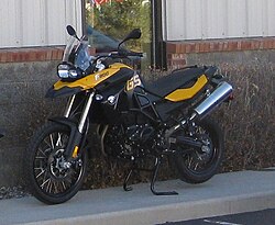 Black and yellow F800GS parked against the wall of a building