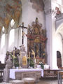 A white cloth covering an ornate stone altar