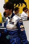 Damon Hill in racing uniform walking to the right