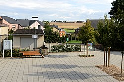 A row of multicolored houses in front of a field