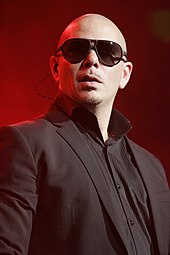 A man wearing sunglasses, a black shirt, and a black blazer.