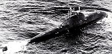 A black-and-white image of a submarine that has partially risen above the water