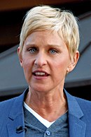 Headshot of a blond haired female in her early fifties wearing a blue jacket over blue and white shirts.