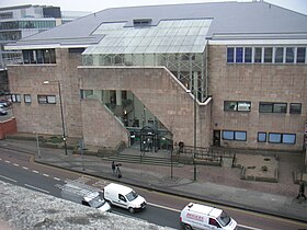 Elevated view of a light coloured building alongside a road