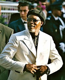 Jackson buttoning his white suit at the Cannes Film Festival in 2005