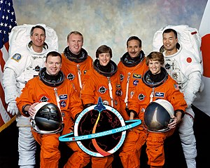 In front are astronauts Eileen M. Collins (right), commander; Wendy B. Lawrence, mission specialist; and James M. Kelly, pilot. In back are astronauts Stephen K. Robinson (left), Andrew S. W. Thomas, Charles J. Camarda, and Soichi Noguchi, all mission specialists. Noguchi represents Japan Aerospace Exploration Agency (JAXA).