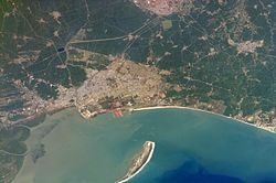 Aerial view of water, a curved shore and a sandspit