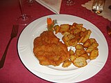 Kotlet schabowy served with fried potatoes