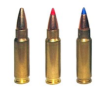 Photo of three 5.7×28mm cartridges as used in the P90. The left cartridge has a plain hollow tip, the center cartridge has a red plastic V-max tip, and the right cartridge has a blue plastic V-max tip.