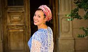 A woman wearing a headwrap that exposes a "tefach" (maximum acceptable amount) of hair