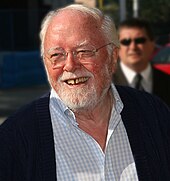 A photograph of a smiling old man with white hair and beard