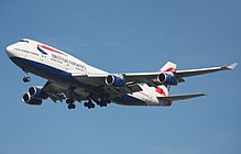 A British Airways 747-400 in white, blue and red livery on approach with its landing gear extended.