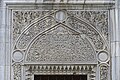 Tímpano de mármol tallado sobre una ventana exterior de la mezquita.